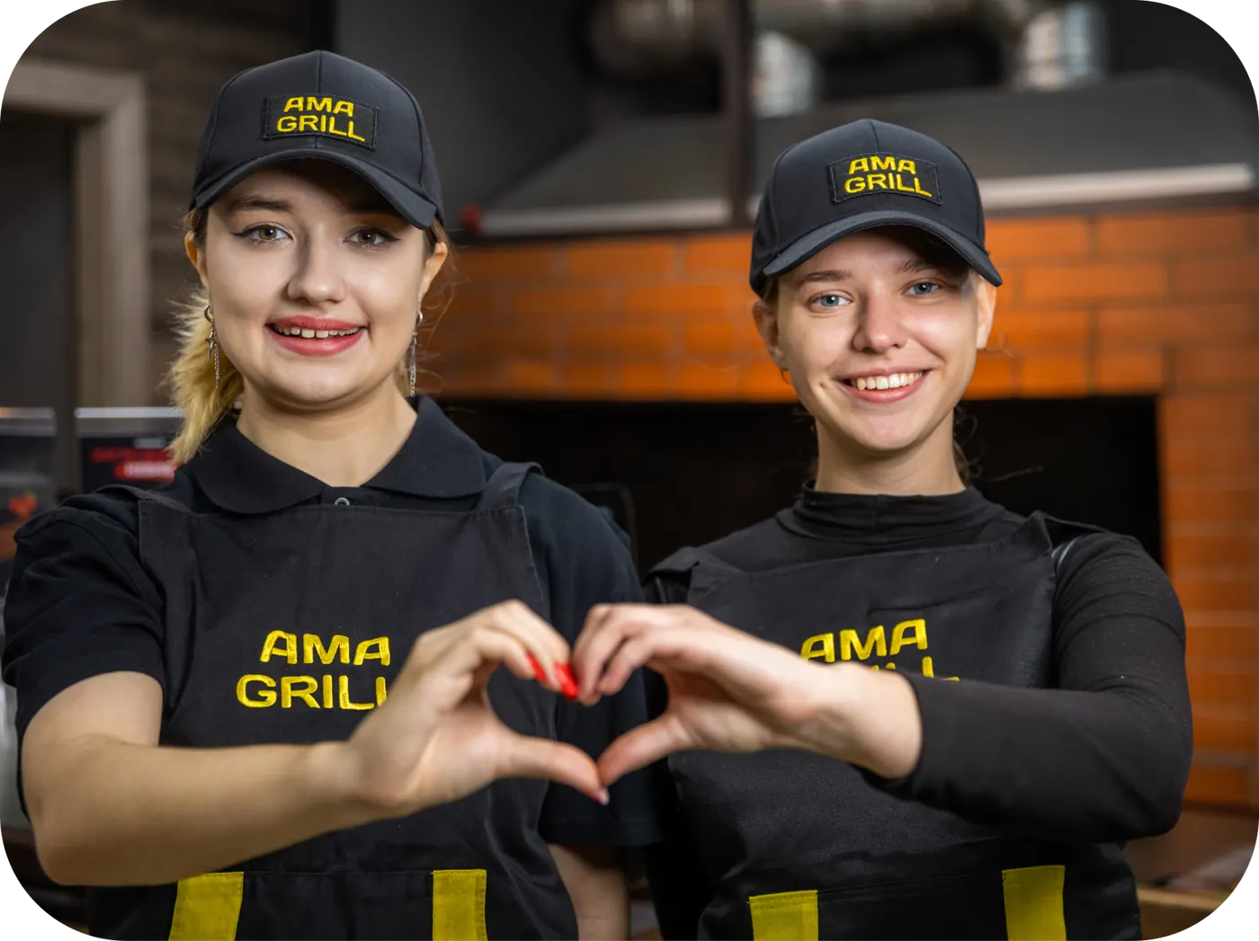 Сотрудники «Ама Гриль» в фирменной форме складывают руки в форме сердца